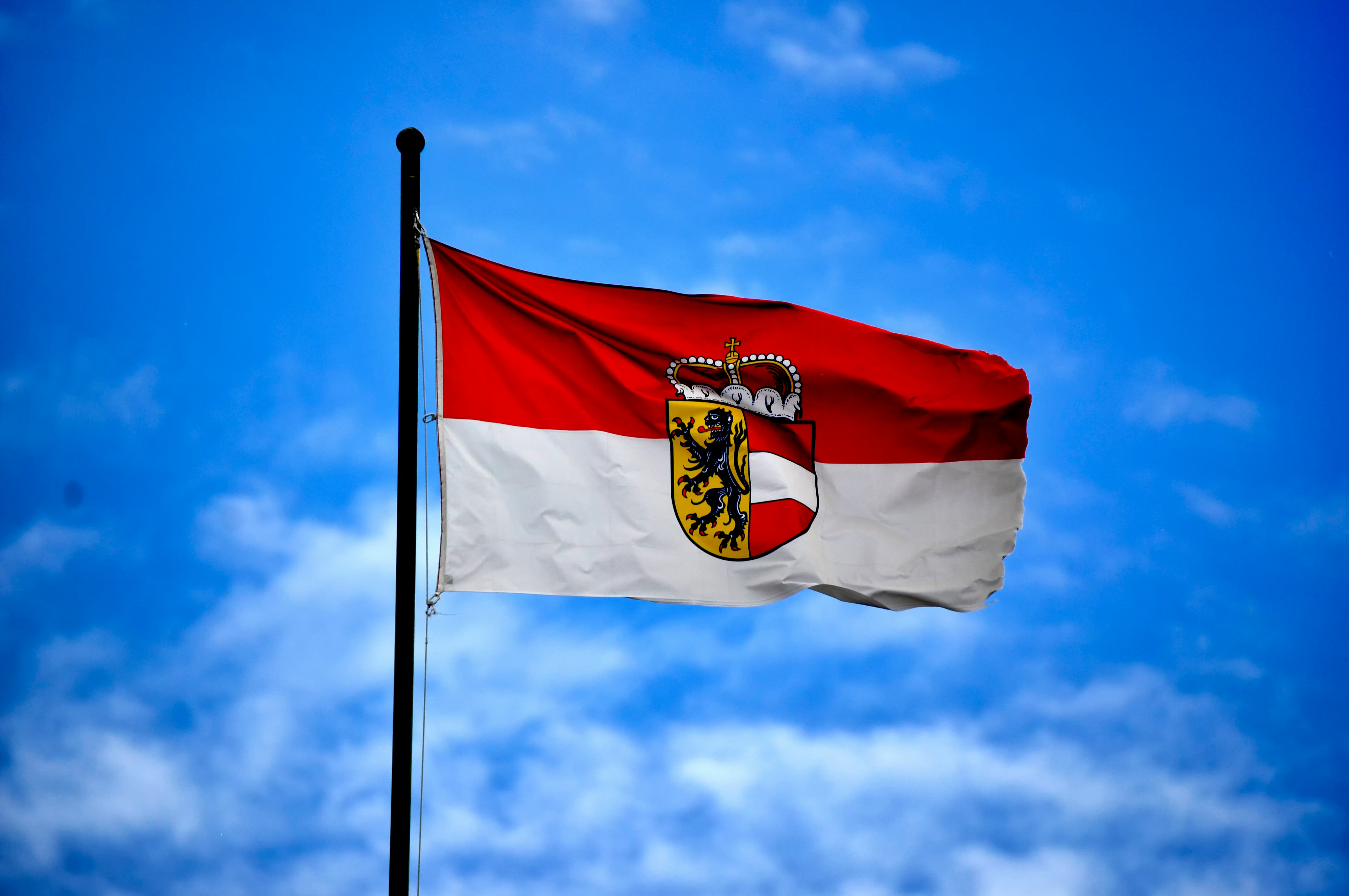 white and red flag on top of flagpole during daytime